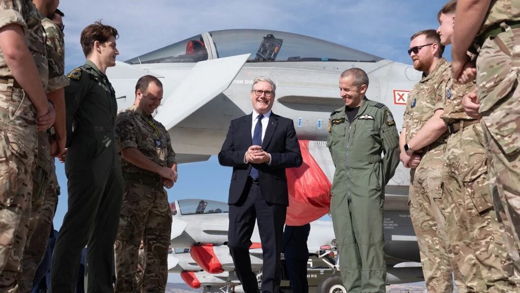 Britain's Prime Minister Keir Starmer (C) speaks with British armed forces personnel in front of a UK Typhoon fighter jet at Tusas airbase in Ankara, on October 27, 2025, during a visit to Turkey.