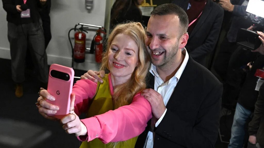 Green Party candidate Hannah Spencer poses for a selfie with Green Party leader Zack Polanski after winning the Gorton and Denton Parliamentary by-election, at Manchester Central Convention Complex in Manchester, northern England on February 27, 2026. (AFP)