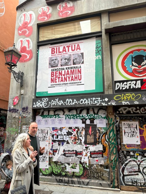 People walk past an anti-Israel poster in downtown Bilbao (Azad/Essa/MEE)