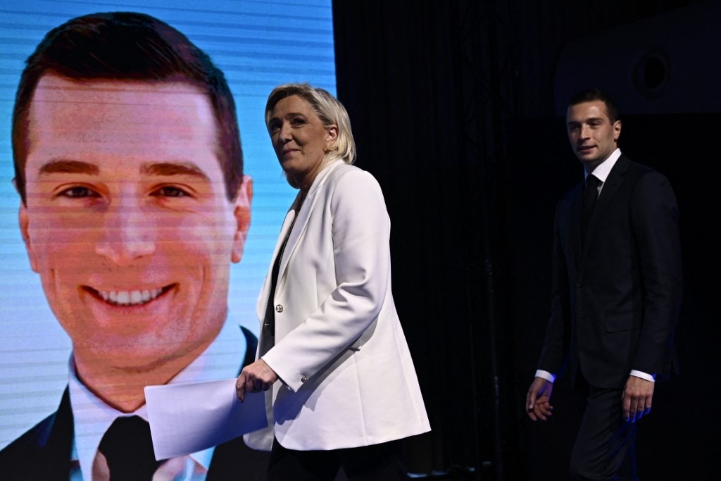 RN leaders Marine Le Pen and Jordan Bardella arrive on stage to address followers after French President Emmanuel Macron announced new general elections, on 30 June in Paris (Julien de Rosa/AFP)