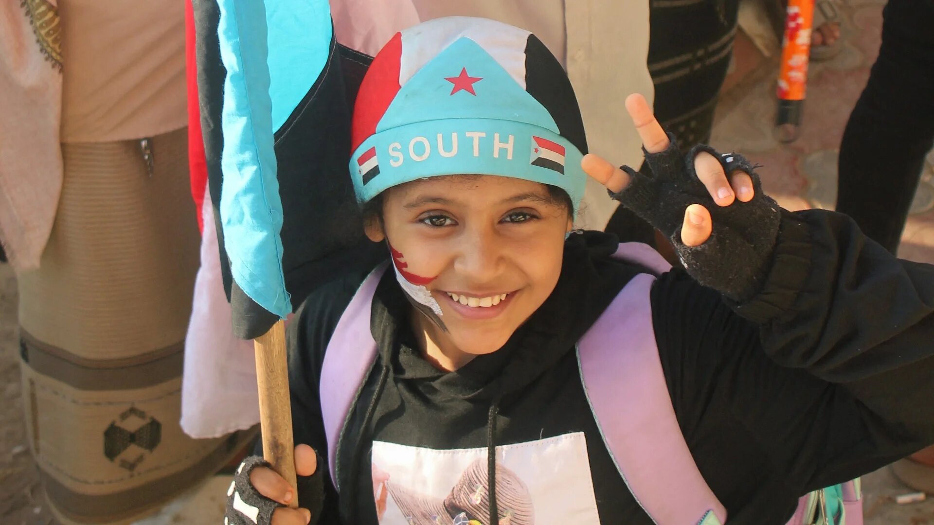 A Yemeni child, wearing a hat in the colours of the old South Yemen flag, joins supporters of the UAE-backed Southern Transitional Council at a rally in Aden's al-Aroud Square demanding a "second independence", 8 December 2025 (AFP/handout)