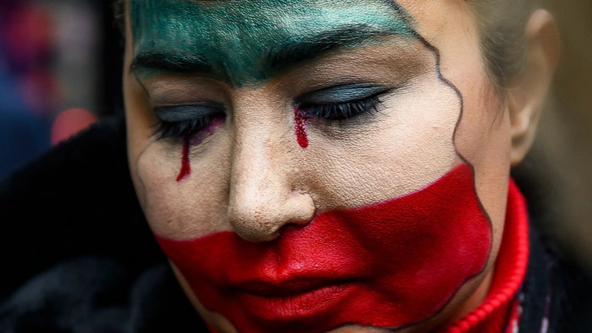 An anti-Iranian govenment protester with her face painted in the colours of Iran's flag takes part in a demonstration outside the Iranian consulate, in Istanbul, on 11 January 2026 (Yasin Akgul/AFP)