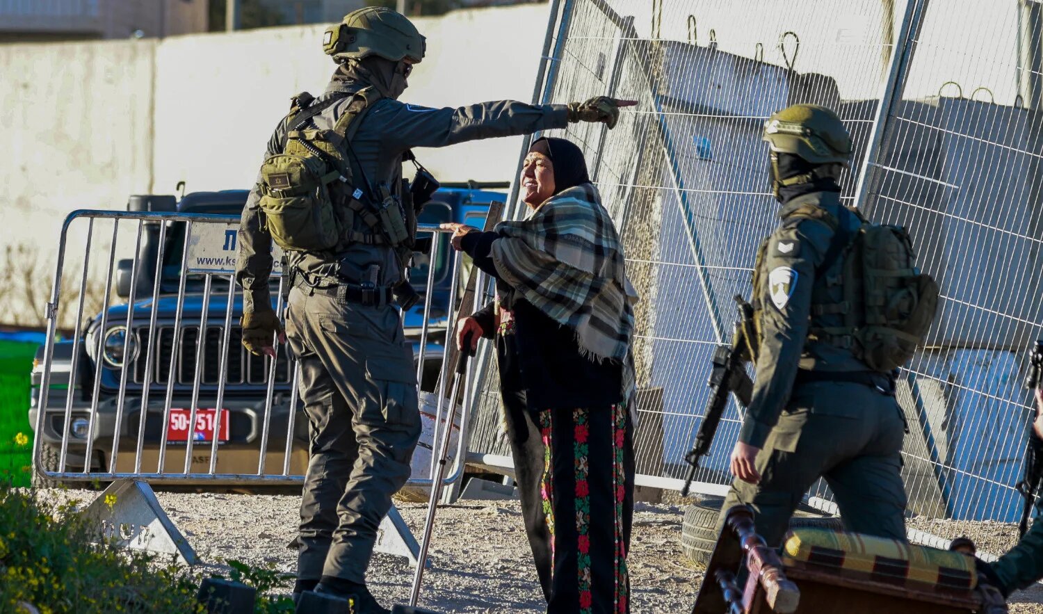 Israeli soldiers speak with a Palestinian woman at the Qalandia checkpoint in the occupied West Bank city of Ramallah on 20 February 2026 as she tries to enter Jerusalem on her way to Al-Aqsa Mosque (AFP)
