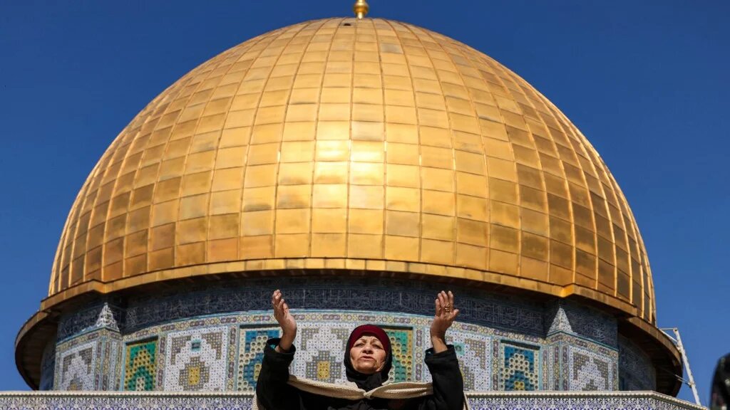 A woman prays near the Dome of the Rock shrine at Al-Aqsa Mosque complex in the Old City of Jerusalem on 20 February 2026 (Ahmad Gharabli/AFP)