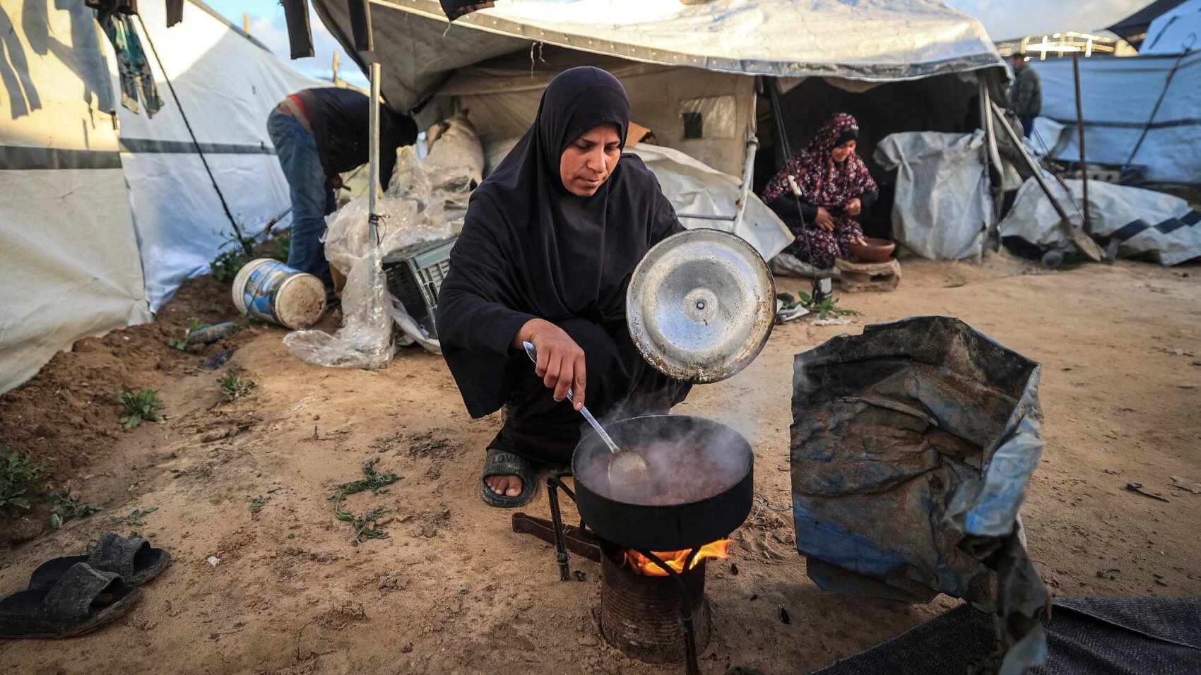 A Palestinian woman prepares a meal for the fast-breaking meal during the Muslim holy month of Ramadan, in Nuseirat Refugee Camp, in the central Gaza Strip on 26 February 2026 (AFP)