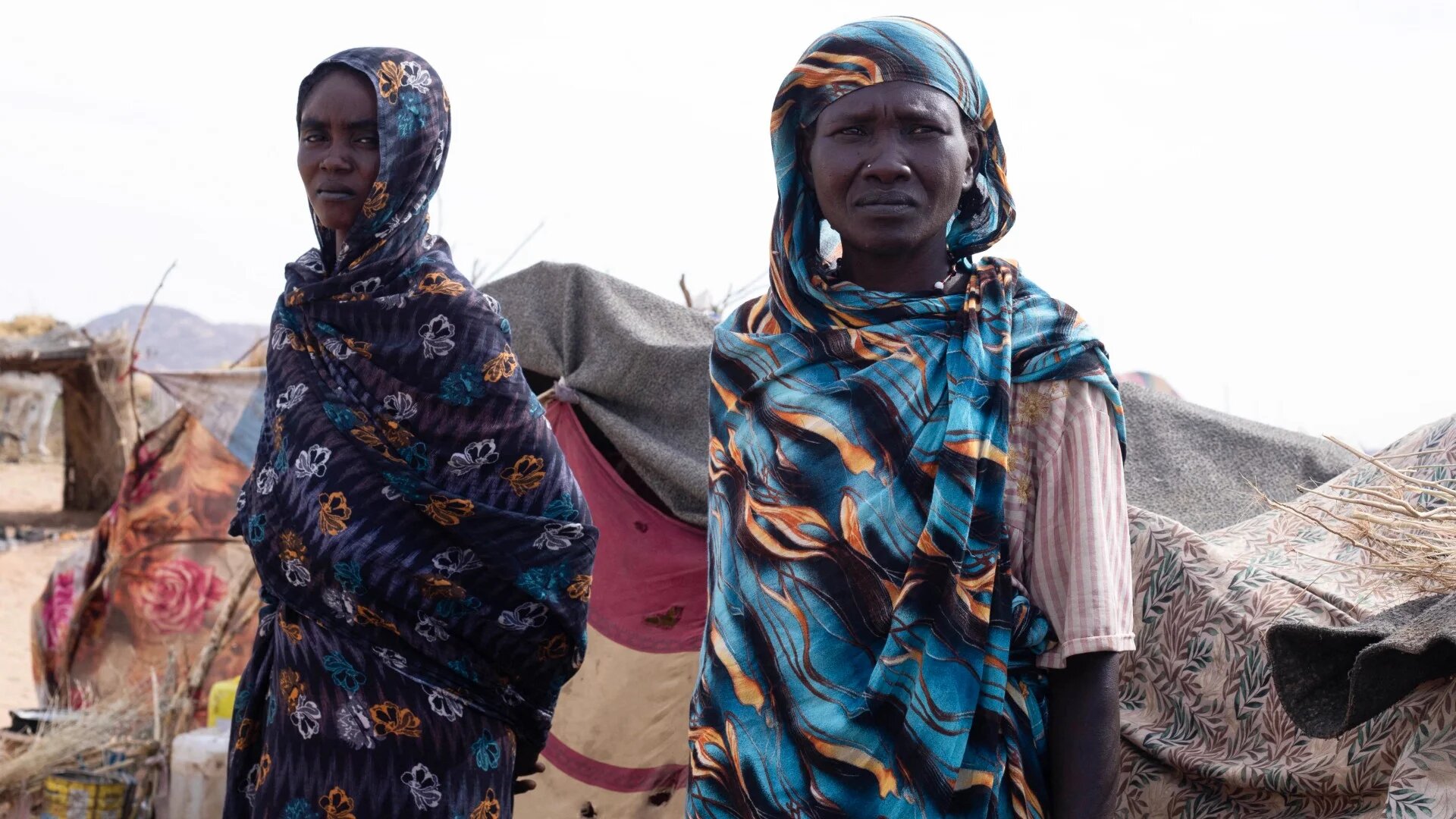 Displaced Sudanese women who fled el-Fasher stand in front of their makeshift shelter in the Um Yanqur camp in Tawila on 3 November 2025 (AFP)
