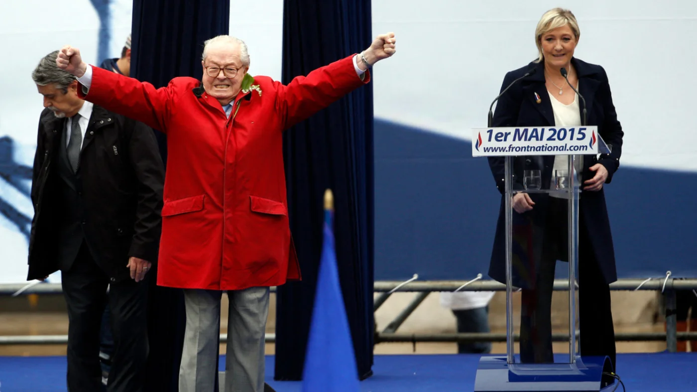 Jean-Marie Le Pen gestures on stage as Front National president Marine Le Pen gives a speech during the party's annual Joan of Arc rally in Paris, on 1 May 2015 (AFP