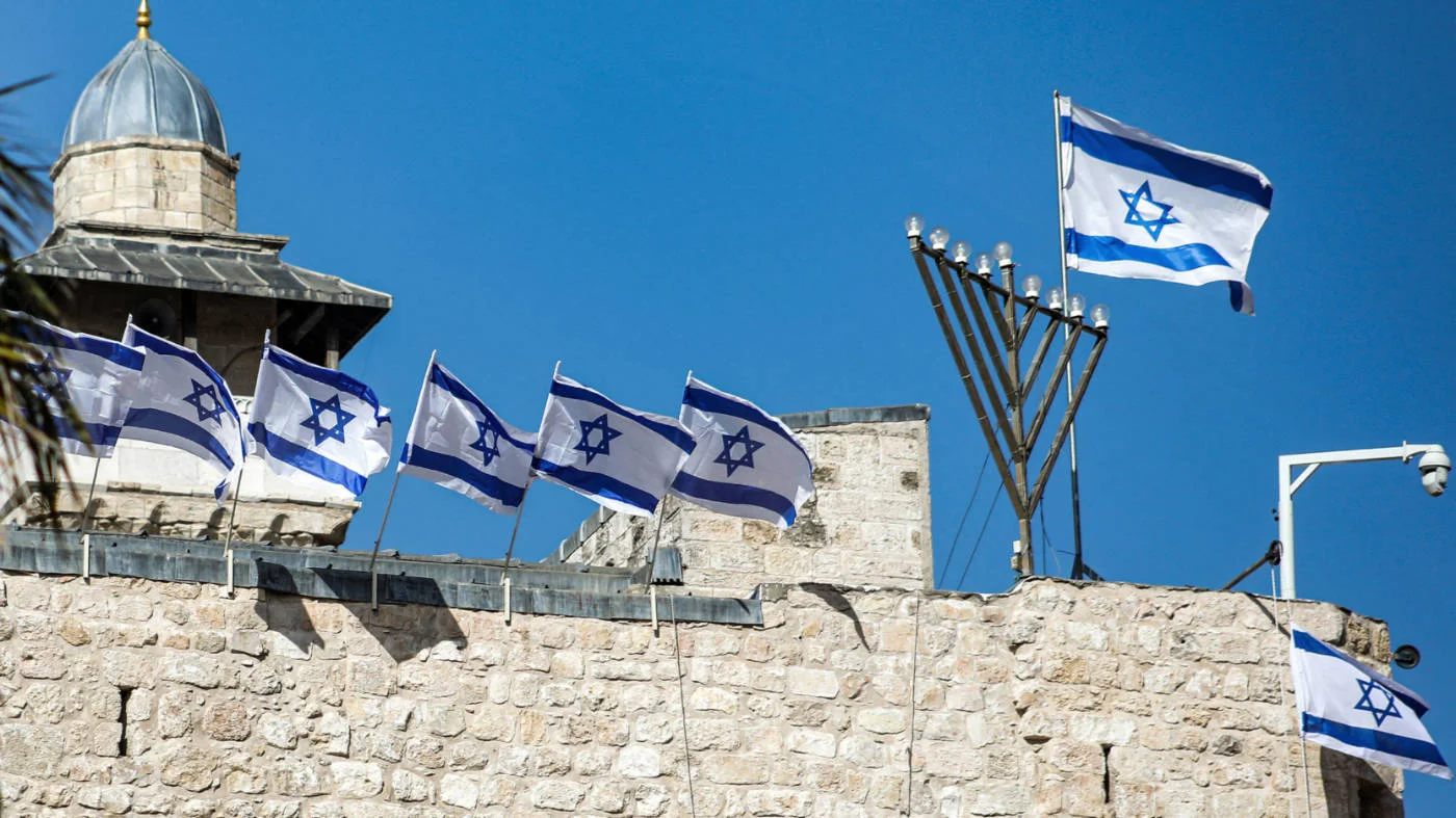 Israeli flags and menorah are placed atop the walls of the Ibrahimi Mosque, Hebron, to mark Israel's 75th Independence Day celebrations in April 2023 (AFP)