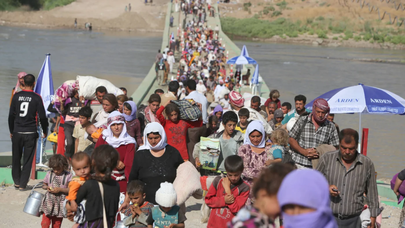 Yazidis from northern Iraq cross the Tigris river into Syria to escape atrocities committed by Islamic State in August 2014 (AFP)