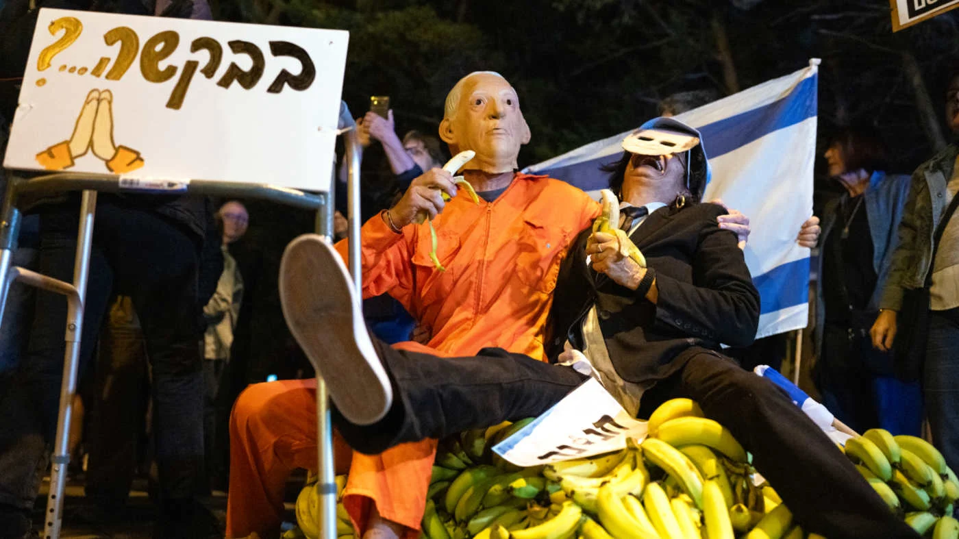 Demonstrators pretending to be Israeli Prime Minister Benjamin Netanyahu and Israeli President Isaac Herzog demonstrate outside Herzog's house in Tel Aviv on 30 November 2025 (AFP)