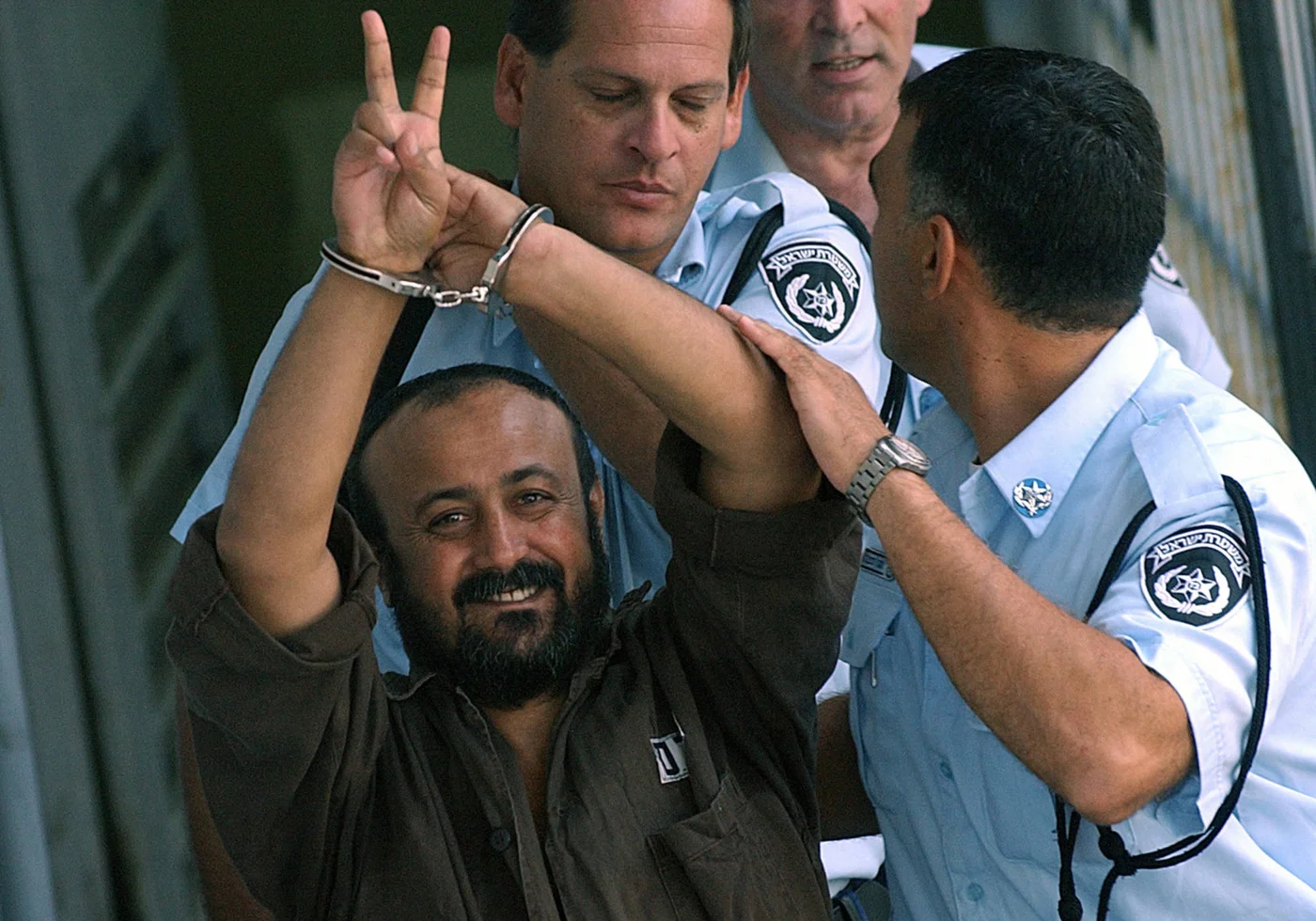 Marwan Barghouti is led to a police vehicle after appearing before a Tel Aviv court in September 2003 (AFP)