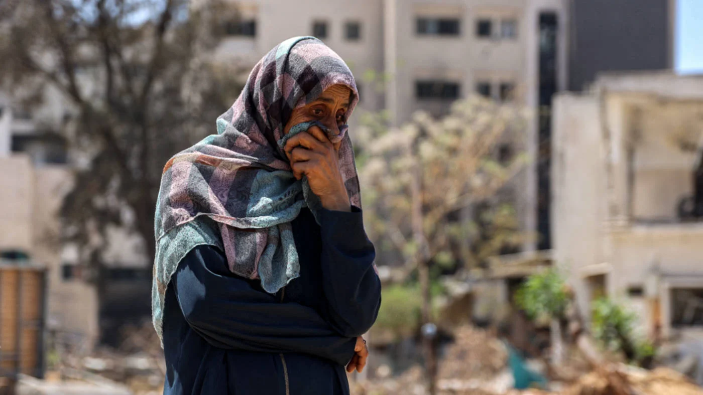  A woman watches Palestinian forensic experts search for bodies of dead people near Al-Shifa Hospital in Gaza City in April 2024 (AFP)
